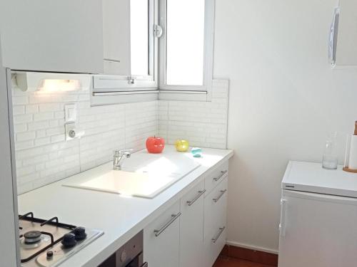 une cuisine blanche avec un évier et une fenêtre dans l'établissement Studio lumineux pour 2, vue océan avec parking privatif à La Rochelle - FR-1-551-40, à La Rochelle