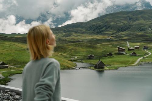 a woman looking out over a lake in the mountains at Frutt Mountain Resort in Frutt