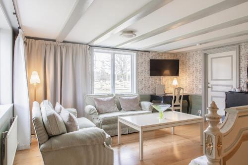 a living room with a couch and a table at Stufvenäs Gästgifveri in Söderåkra