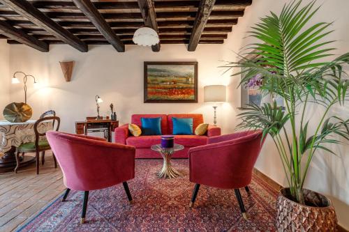 a living room with a red couch and two chairs at Borgodoro - Natural Retreat in Magliano Sabina