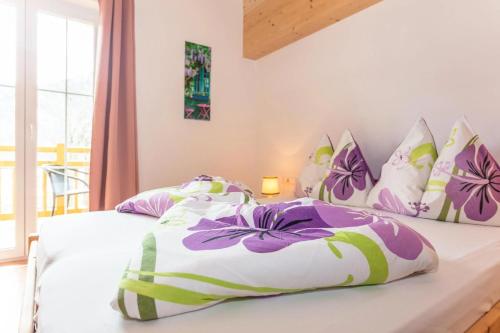 a bedroom with two beds with purple and white pillows at Haus Garten An der Sonne in Niedernsill