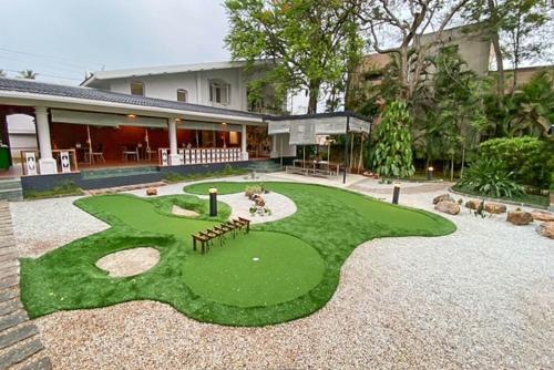 a fake golf course in front of a house at StayVista at Ananta - Breakfast Included & Basketball Court in Bengaluru