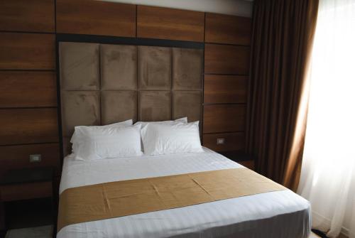 a bedroom with a large bed with a wooden headboard at Hilal Palace - Halal in Golem