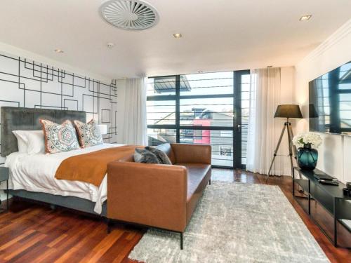 1 dormitorio con 1 cama y 1 sofá en Heriot Properties Units 19 & 20 en Johannesburgo