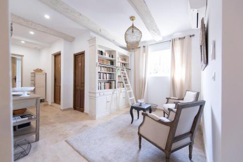 a room with a desk and chairs and a book shelf at La Bastide des Lavandins in Le Thor