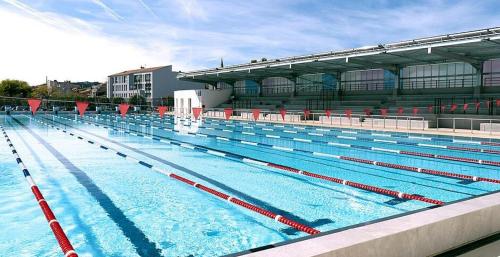 a large swimming pool with a large building at T3 avec grande terrasse et jardin sur les hauteurs de Martigues in Martigues