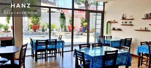 restauracja z niebieskimi stołami i krzesłami oraz oknem w obiekcie HANZ Anh Duc Hotel w mieście Thu Dau Mot