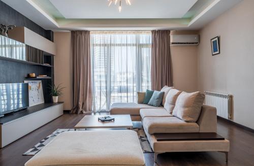 - un salon avec un canapé et une télévision dans l'établissement lovely space in vake with balcony,2 bedroom apt., à Tbilissi