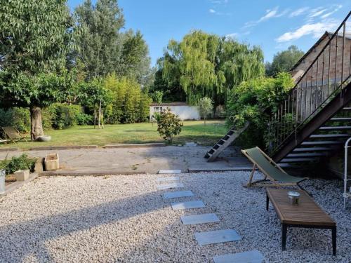 un patio trasero con un banco, una mesa y escaleras en St Rèmy de Provence, La Maison du Berger, en Saint-Andiol