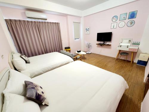 a hotel room with two beds and a television at Tongxinyu Homestay in Wujie
