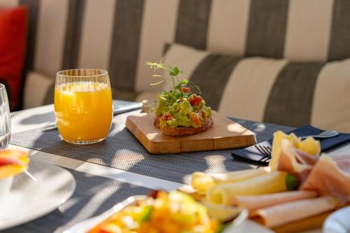 a table with a plate of food and a glass of orange juice at Tara's Lodge in Korčula