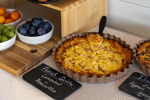 a pie sitting on top of a table next to bowls of fruit at Tara's Lodge in Korčula