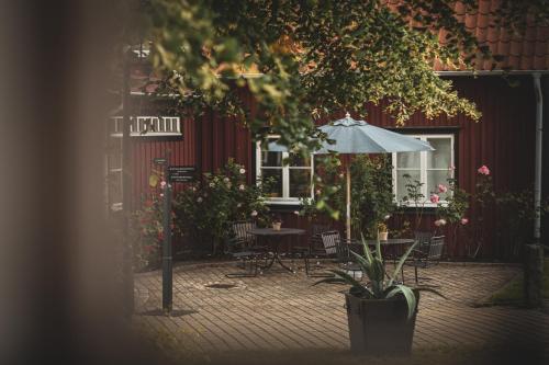 a patio with a table and an umbrella at Stufvenäs Gästgifveri in Söderåkra