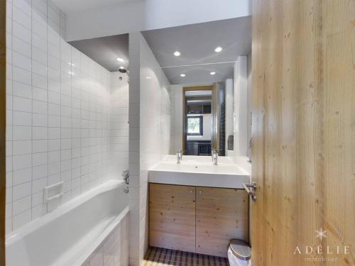 a bathroom with a tub and a sink and a tub and a mirror at Appartement Montvalezan-La Rosière, 3 pièces, 6 personnes - FR-1-398-590 in Montvalezan