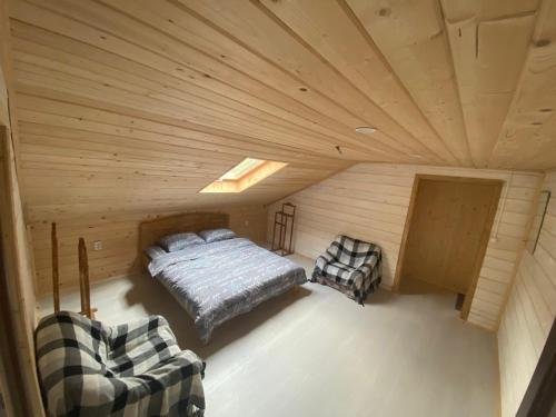 a bedroom with a bed and two chairs in a room at 4 Mountains Hotel in Bystrets