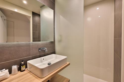 a bathroom with a white sink and a shower at Logis Hôtel & Spa Déjeunez Sous L'Arbre in Rousset