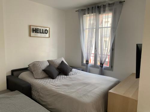 une chambre avec un lit avec des oreillers et une fenêtre dans l'établissement Appartement familial, à Chessy, la ville de Disneyland Paris, à Chessy