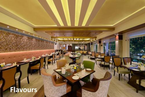 ein Restaurant mit Tischen und Stühlen in einem Raum in der Unterkunft Glenview Resort Kasauli, a member of Radisson Individuals in Kasauli