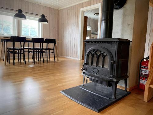 a fireplace in a living room with a table and chairs at Stryn - Faleide -hytte med fjord og fjell utsikt in Stryn