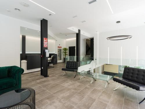 a lobby with black chairs and a glass table at Hotel MG Poniente in Las Palmas de Gran Canaria