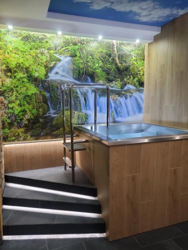 a bathroom with a waterfall mural on the wall at Wellness Resort Kamzík in Ždiar