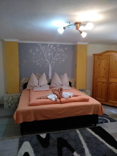 a bedroom with a bed with a tree mural on the wall at Margaréta Panzió in Sárospatak