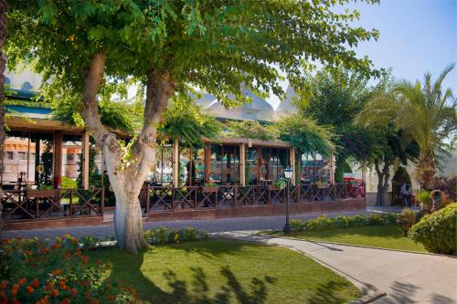 a building with a tree in the middle of a park at Kamelya Aishen Club & Aqua Ultra All Inclusive Kids Concept in Side