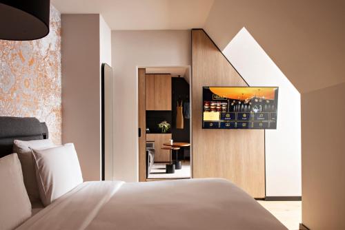 斯特拉斯堡Hôtel LÉONOR the place to live的一间带白色床的卧室和一间厨房