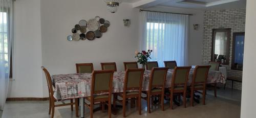 una sala da pranzo con un tavolo e un mucchio di sedie di Natura Chalet a Gîlgău