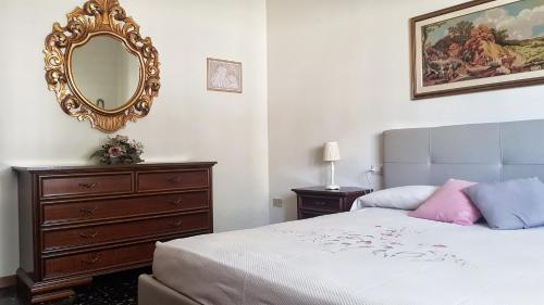 una camera da letto con un letto con specchio e un comò di Casa MARIA , Appartamento nel cuore della Toscana a Larciano