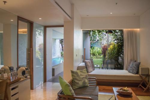 a living room with a couch and a large window at Maya Sanur Resort & Spa in Sanur
