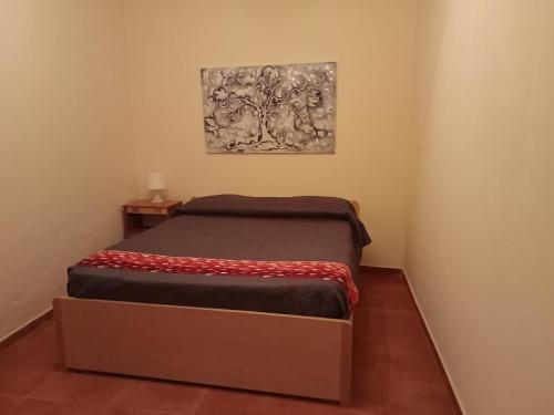 1 cama en una habitación con un cuadro en la pared en Capo Vaticano 7km Casa vacanze in Monte Poro en Coccorino