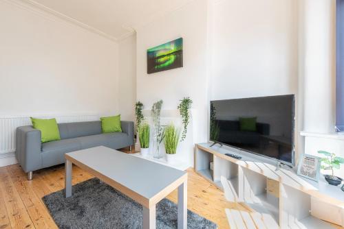 a living room with a couch and a flat screen tv at Jasmine Villa B - Ideal for QMC & Uni - Free parking in Nottingham