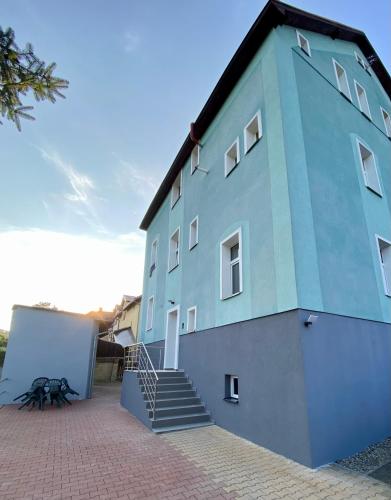 a blue building with stairs on the side of it at Berta's Apartments in Děčín