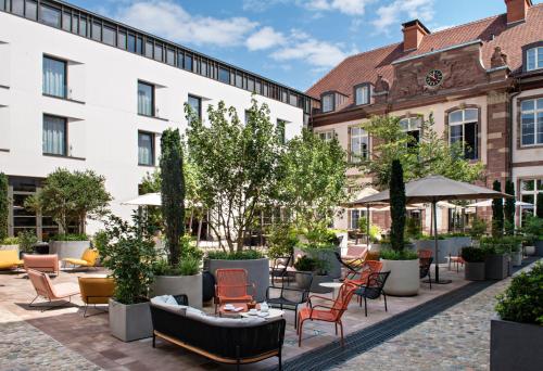 a courtyard with chairs and tables and buildings at Hôtel LÉONOR the place to live in Strasbourg