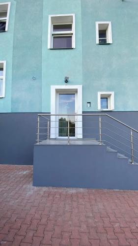 a blue building with stairs in front of it at Berta's Apartments in Děčín