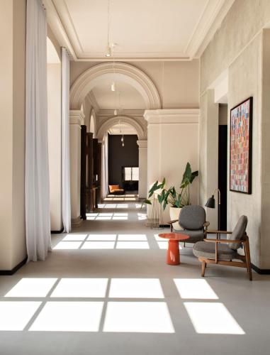 a hallway in a building with a couch and a chair at Hôtel LÉONOR the place to live in Strasbourg
