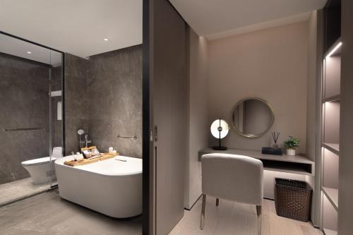 uma casa de banho com um lavatório, um WC e um espelho. em Somerset Daxing Beijing em Daxing