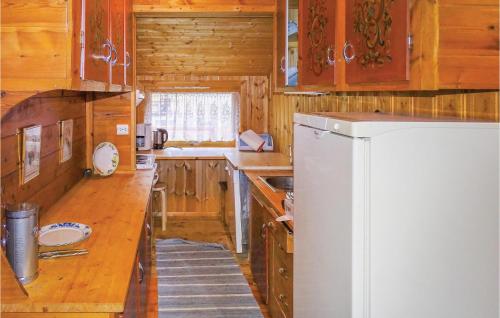 a kitchen with a white refrigerator and wooden cabinets at Lovely Home In Dirdal With Ethernet Internet in Dirdal