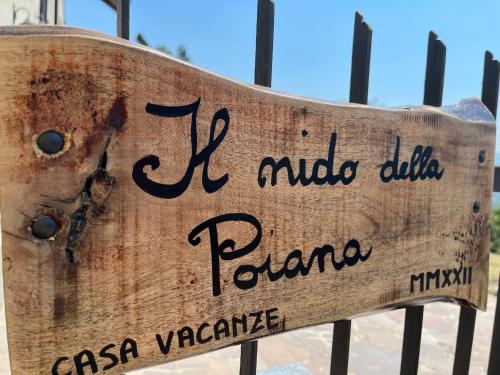 a wooden sign that reads poma on a fence at IL NIDO DELLA POIANA CASA VACANZE e B & B in Montalto Pavese