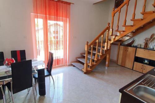 a living room with a staircase and a table and chairs at Kuca za odmor Juraj - Apartmani Barsic in Duga Resa