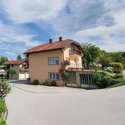 a large house with a balcony on a street at Kuca za odmor Juraj - Apartmani Barsic in Duga Resa