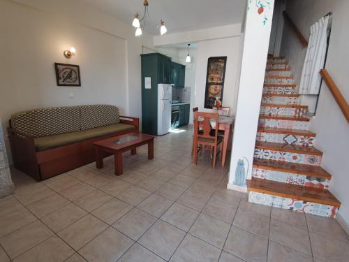 a living room with a staircase and a couch and a table at Taletos Apartments in Stoupa