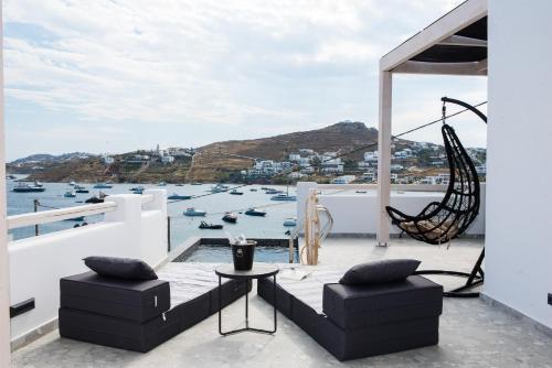 a balcony with a view of the water and boats at BLUE WATERS MYKONOS in Ornos
