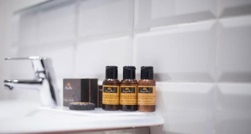 four bottles of oils sitting on a bathroom shelf at The Best Centric Hotel in Nouakchott
