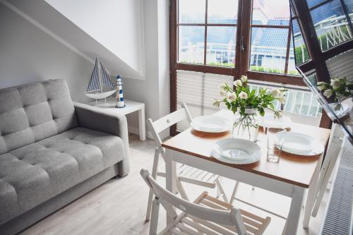a living room with a table and a couch at Apartamenty Liliowa 3 in Dębki