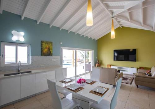 a kitchen and living room with a table and chairs at Airport View 3-Bed Villa in Cupecoy