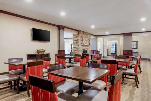 a restaurant with tables and chairs and a flat screen tv at Comfort Inn Plover-Stevens Point in Plover