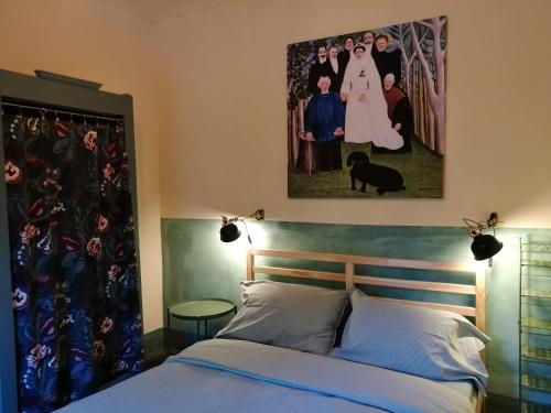 a bedroom with a bed with a painting on the wall at A romantic suite in the countryside near Torino in Pecetto