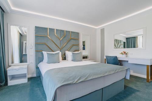a white bedroom with a large bed and a window at 3 Stejari Brasov in Braşov